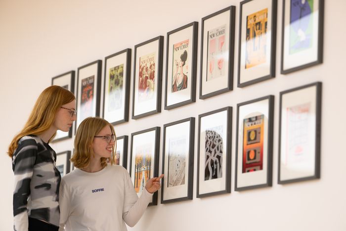 Besucherinnen betrachten die New-Yorker-Cover von Christoph Niemann. Foto: Mohssen Assanimoghaddam