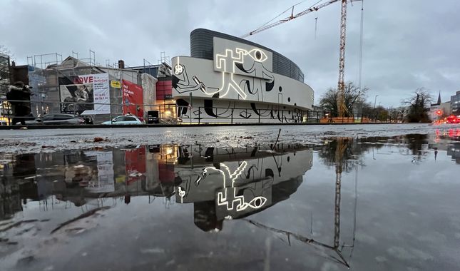 Fassadenkunst spiegelt sich in Pfütze. Foto: Torsten von Reeken