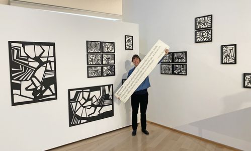 Künstlerin und Stipendiatin Aline Helmcke hängt ihre Papierschnitte "Splitterland" auf. Foto: Horst-Janssen-Museum