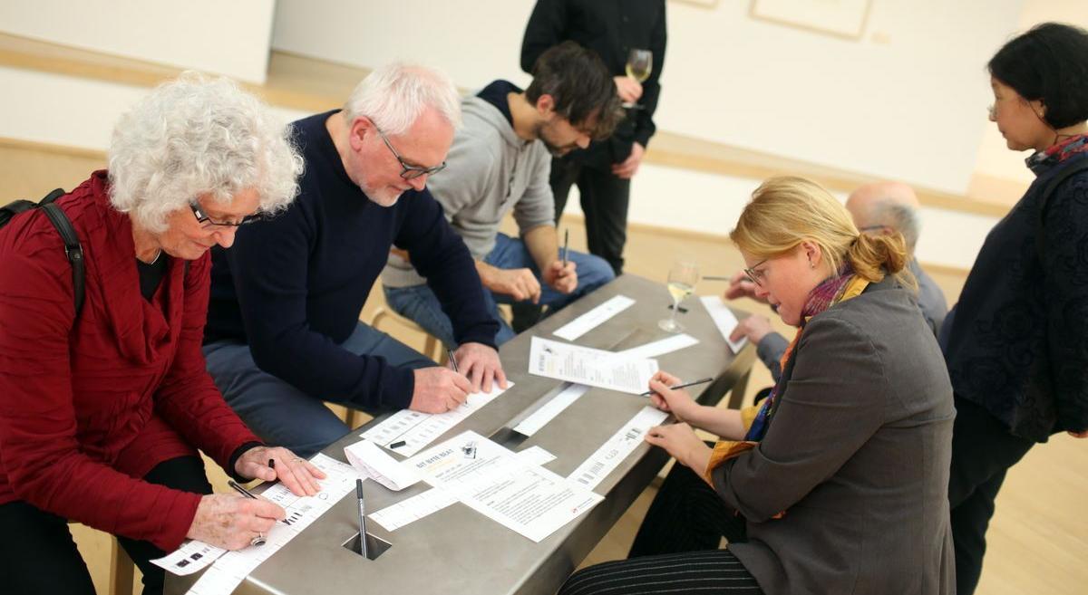 Besucher probieren eine Bild-Rhythmusmaschine bei einer Ausstellungseröffnung aus. Foto: Markus Hibbeler