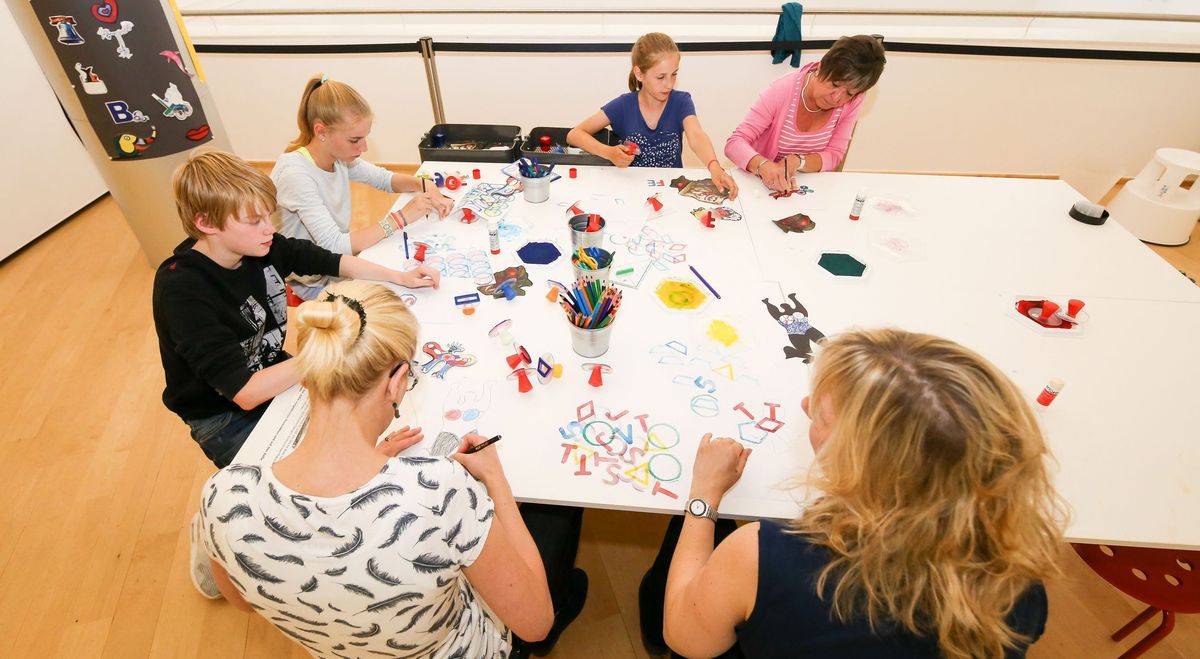 Visitors stamp and draw at a hands-on station. Photo: Mohssen Assanimoghaddam